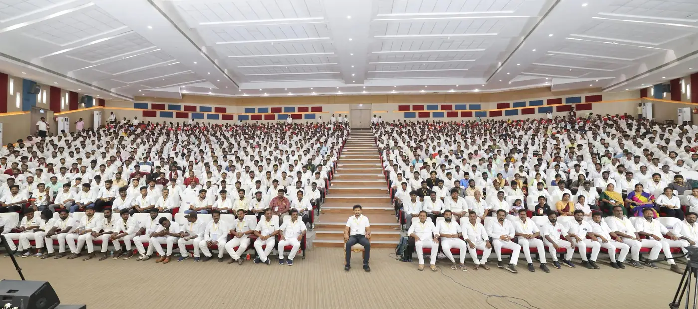 Young cadres seated together in a large hall